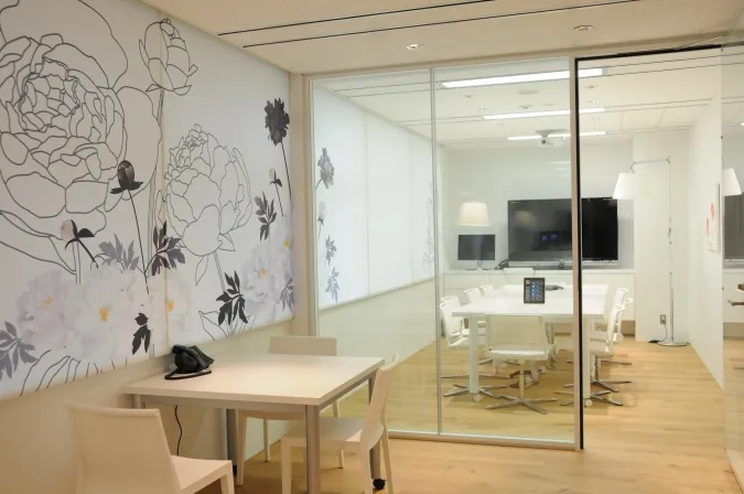 A glass meeting room behind a botanical wall